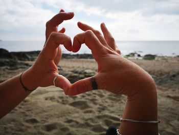 Close-up of hands on sea shore