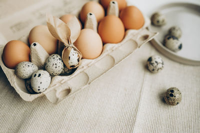 Quail and chicken eggs. gray textile background. happy easter. easter bunny ears decoration.