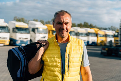 Portrait of caucasian mature man with bag on some-truck vehicles 