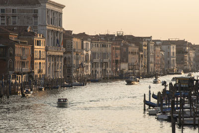 Boats in canal against buildings in city