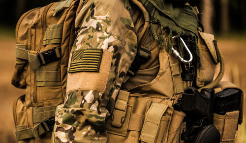 Midsection of solider with backpack