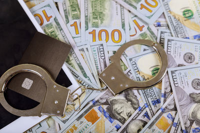High angle view of handcuffs and currencies