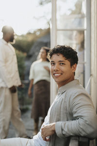 Side view portrait of smiling young man during dinner party at cafe