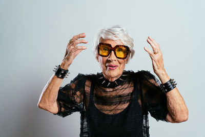 Portrait of young woman wearing sunglasses against white background