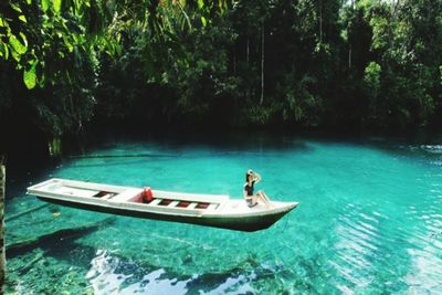 People in boat on lake in forest