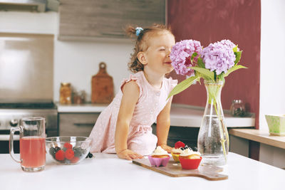 Girl with ice cream on table at home