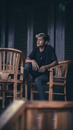 Full length of young man sitting on chair