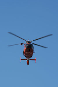 Low angle view of helicopter flying against clear blue sky