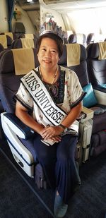 Portrait of smiling woman sitting on seat in bus