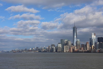 Modern buildings in city against cloudy sky