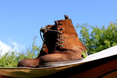 Low angle view of boots against blue sky