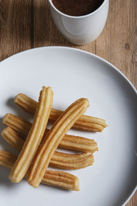 Churros with chocolate on wooden background. isolated and vertical image