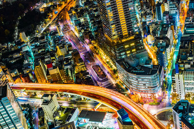 High angle view of illuminated city street and buildings at night