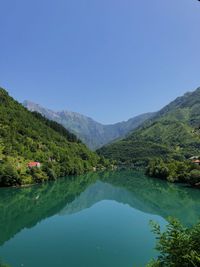 Scenic view of lake and mountains against clear sky