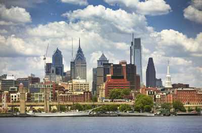 Buildings in city against cloudy sky