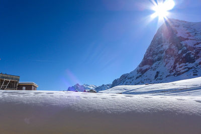 Snow covered mountain against blue sky