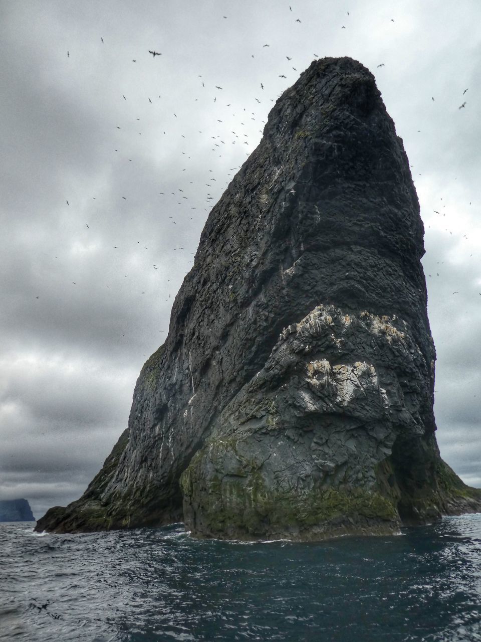 ROCK FORMATION ON SEA AGAINST SKY