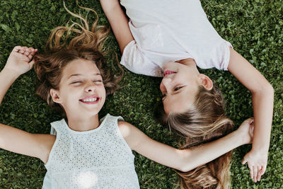 High angle view of siblings lying on grass