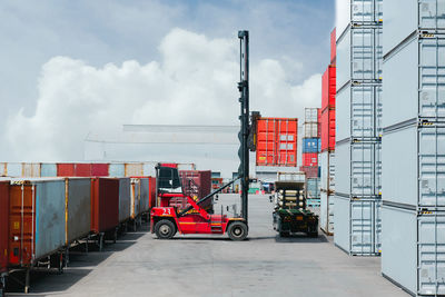 Container forklift moving containers into trucks