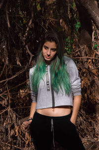 Beautiful young woman standing in forest