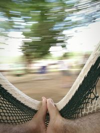 Low section of man relaxing in hammock