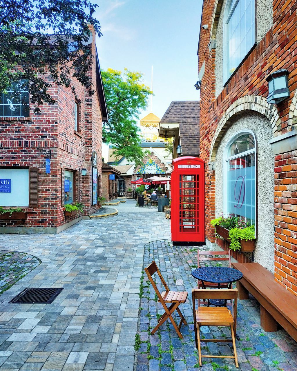 EMPTY CHAIRS AND TABLES ON SIDEWALK AGAINST BUILDING