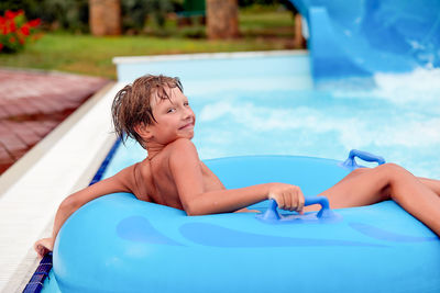 Portrait of boy sitting on inflatable ring