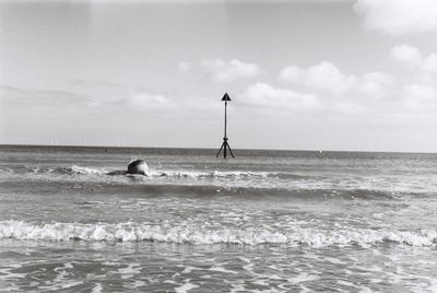 Man swimming in sea against sky