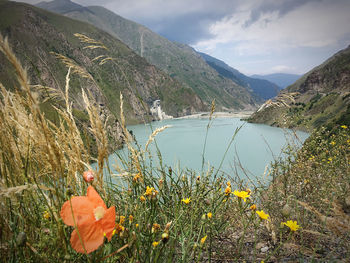 Scenic view of lake by mountains against sky