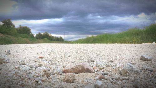 Surface level of stones on field against sky