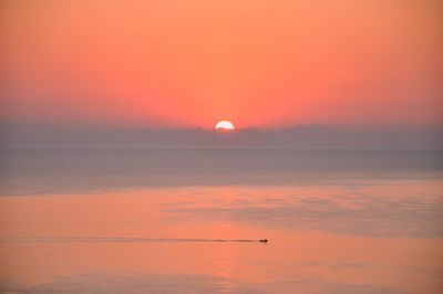 Scenic view of sea against romantic sky at sunset