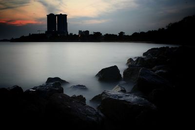 Scenic view of sea against cloudy sky during sunset