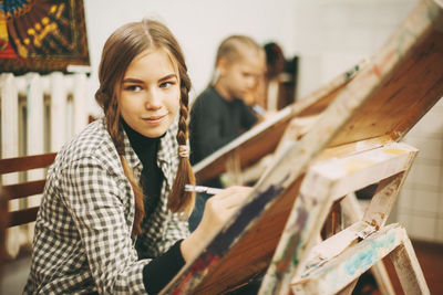 Portrait of young woman sitting on wood