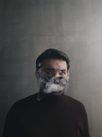 Portrait of man standing against wall