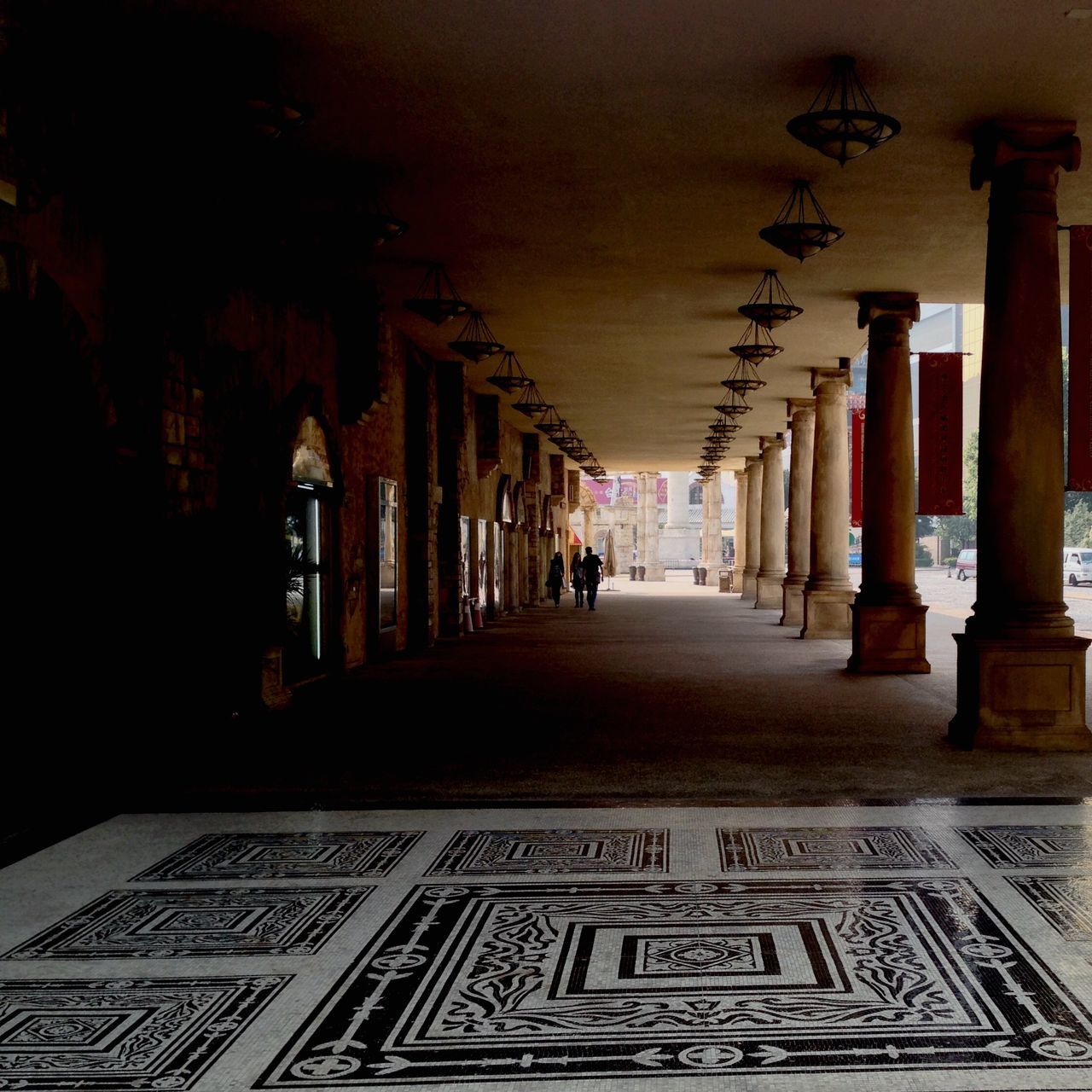 architecture, built structure, the way forward, architectural column, building exterior, in a row, diminishing perspective, column, history, colonnade, text, indoors, corridor, illuminated, travel destinations, incidental people, city, street, building, famous place