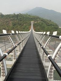 Empty footbridge leading towards mountains