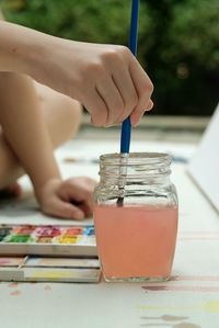 Midsection of person holding ice cream on table