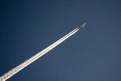 Low angle view of airplane flying against clear sky