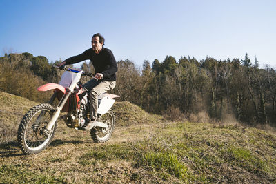 Senior motocross driver riding on circuit