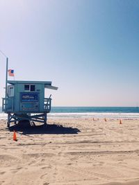 Lifeguard hut with american flag on venice beach against clear sky