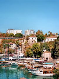 Buildings by sea against clear sky