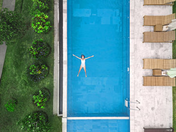 Aerial view of attractive woman floating over water at resort