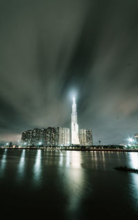 Illuminated city buildings against sky at night