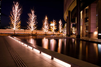 Swimming pool by building at night