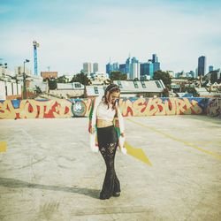 Full length of man skateboarding on city against sky