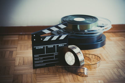 Film reels and slate on hardwood floor