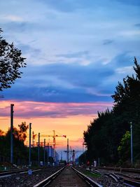 Railroad tracks against sky during sunset