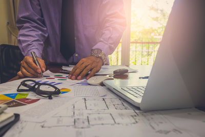 Midsection of man working on table