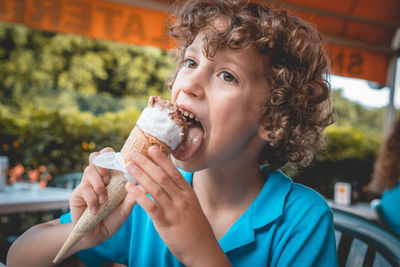 Boy licking ice cream in restaurant