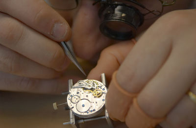 Close-up of hands working on wristwatch